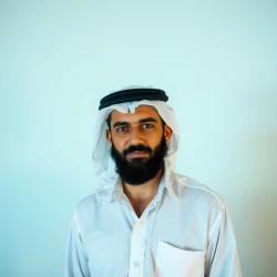 An Arab man in a white shirt and with a black beard